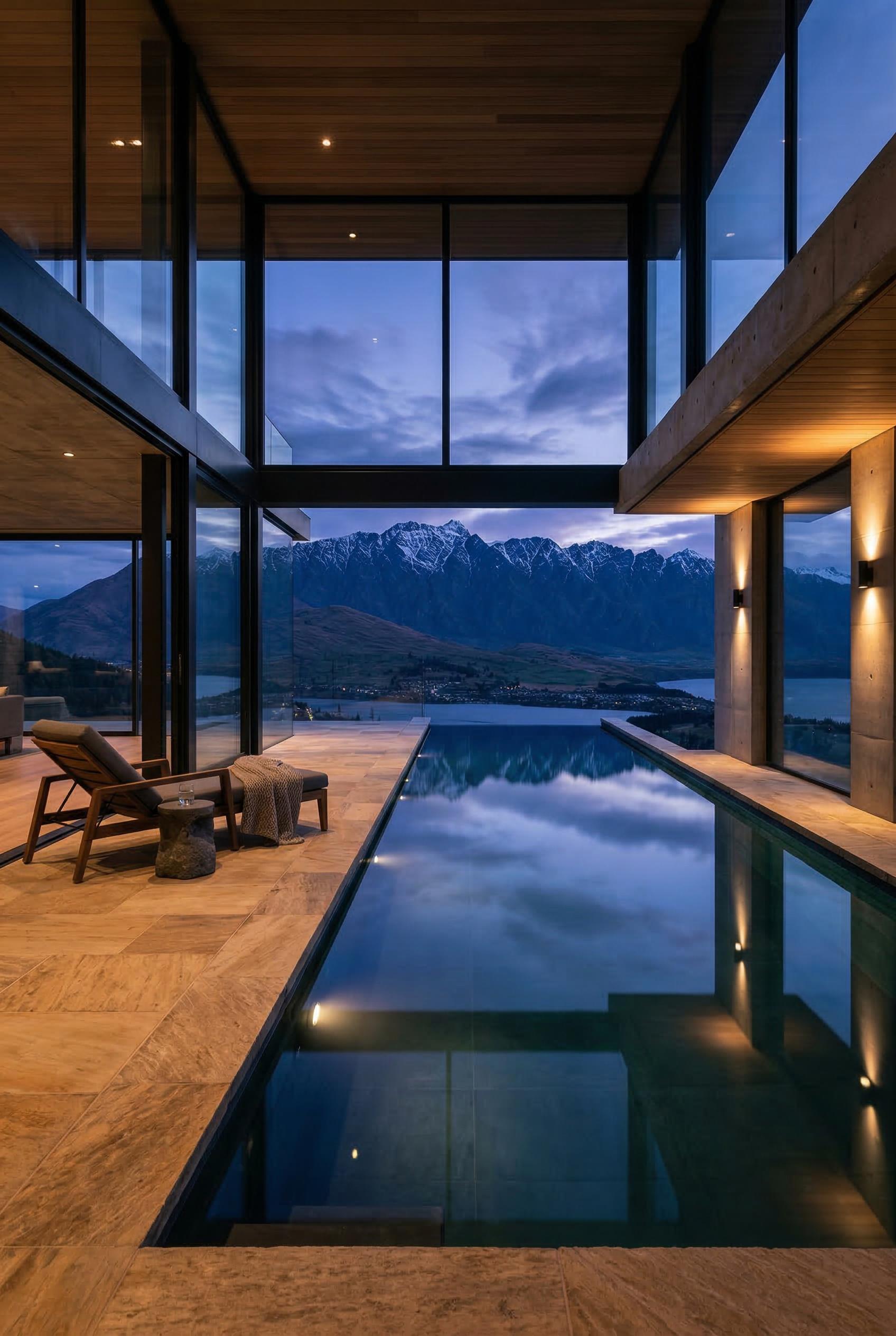 A luxury modern home with an indoor infinity pool, floor-to-ceiling glass walls looking out to mountains, minimalist arc
