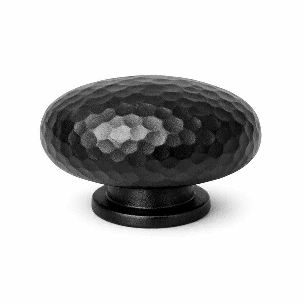 Commercial product photograph. A single residential cabinet knob. Hammered surface texture. Round Knob shape. Matte Blac