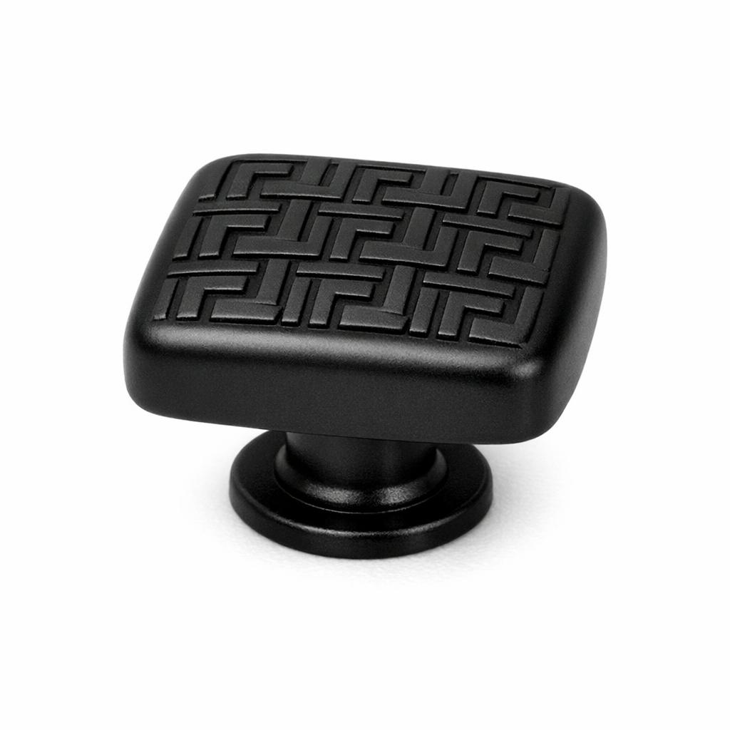 Commercial product photograph. A single residential cabinet knob. Geometric surface texture. Round K
