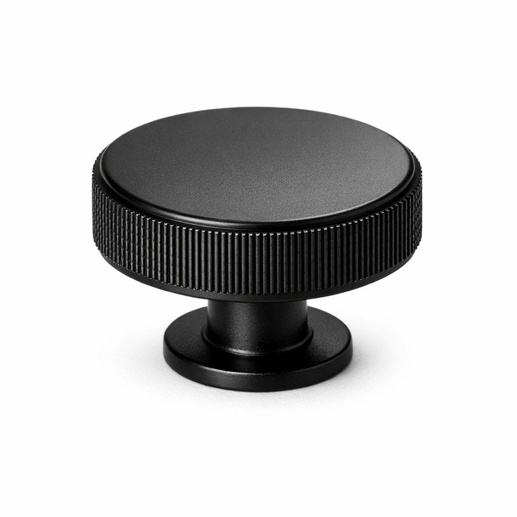 Commercial product photograph. A single residential cabinet knob. Knurled surface texture. Round Knob shape...