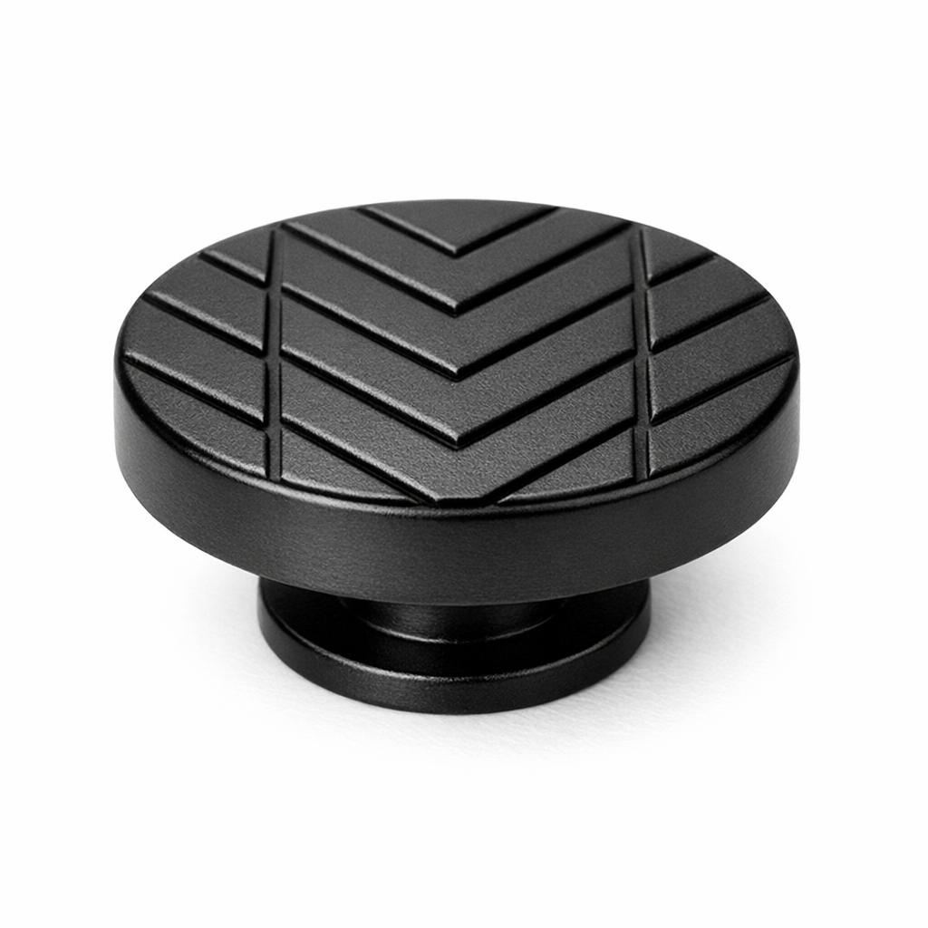 Commercial product photograph. A single residential cabinet knob. Geometric surface texture. Round K