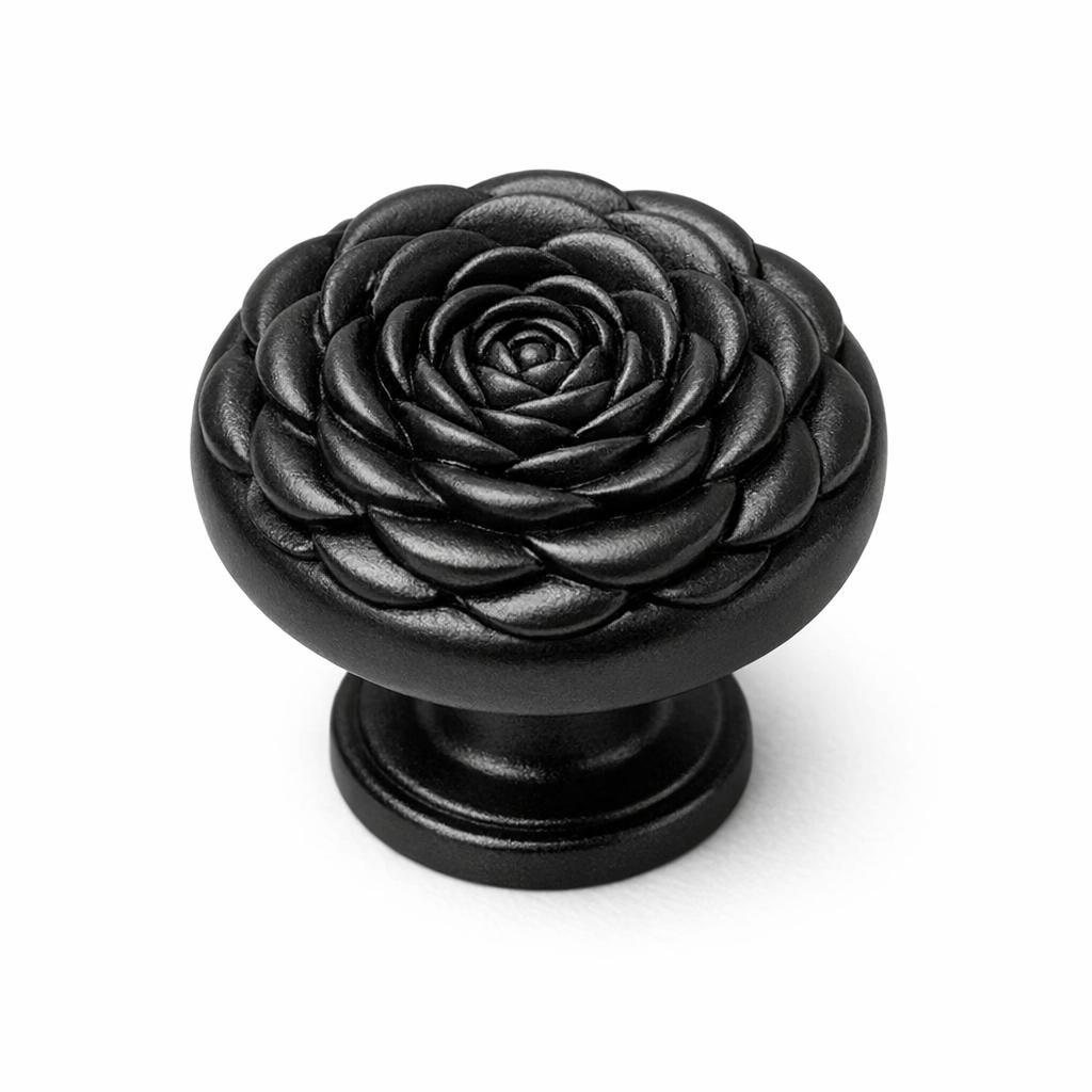 Commercial product photograph. A single residential cabinet knob. Floral surface texture. Round Knob shape. Matte Black metal finish. Small circular base plate, single mounting post, approximately 1-1/4 inch diameter. Photographed on pure white seamless background (#FFFFFF). Studio softbox lighting, soft shadow directly underneath only. Macro lens, sharp focus throughout. Photorealistic real metal hardware. Not a 3D render. Not an illustration. Not CGI. Real cabinet hardware product photography quality. Variation 5: Cabinet knob sculpted as a rosette medallion, concentric rings of overlapping petals spiraling to a center, deep dimensional relief, round form, small round base. Cast metal floral hardware..