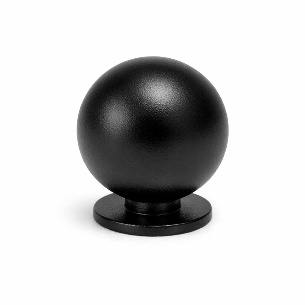 Commercial product photograph. A single residential cabinet knob. Smooth surface texture. Round Knob shape. Matte Black metal finish. Small circular base plate, single mounting post, approximately 1-1/4 inch diameter. Photographed on pure white seamless background (#FFFFFF). Studio softbox lighting, soft shadow directly underneath only. Macro lens, sharp focus throughout. Photorealistic real metal hardware. Not a 3D render. Not an illustration. Not CGI. Real cabinet hardware product photography quality. Variation 2: Ball knob: perfect sphere shape, small flat circular base ring, thin mounting post. Like a solid metal ball sitting on a tiny ring..
