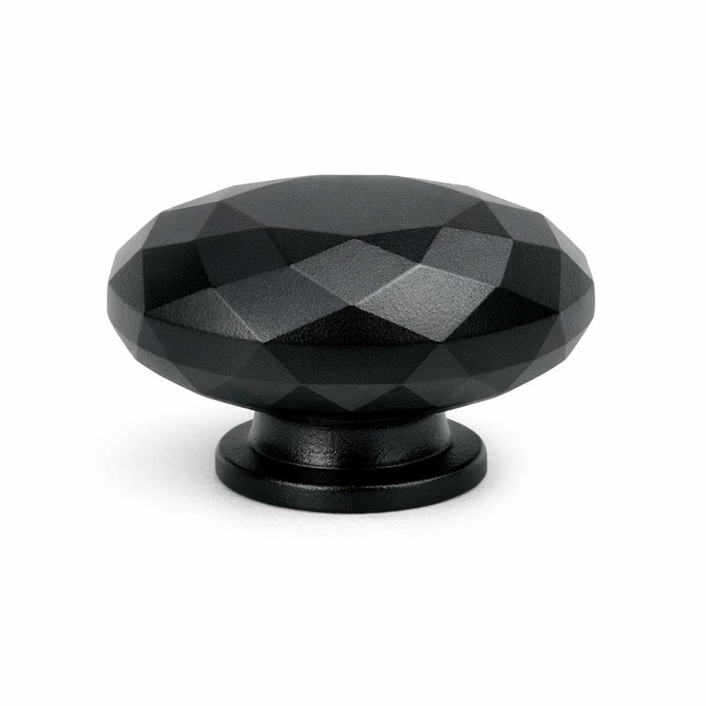 Commercial product photograph. A single residential cabinet knob. Faceted surface texture. Round Knob shape. Matte Black metal finish. Small circular base plate, single mounting post, approximately 1-1/4 inch diameter. Photographed on pure white seamless background (#FFFFFF). Studio softbox lighting, soft shadow directly underneath only. Macro lens, sharp focus throughout. Photorealistic real metal hardware. Not a 3D render. Not an illustration. Not CGI. Real cabinet hardware product photography quality. Variation 10: Basin style cabinet knob: a squat oblate round knob cut into flat angular gem-like facets all over the rounded surface, small short circular base..