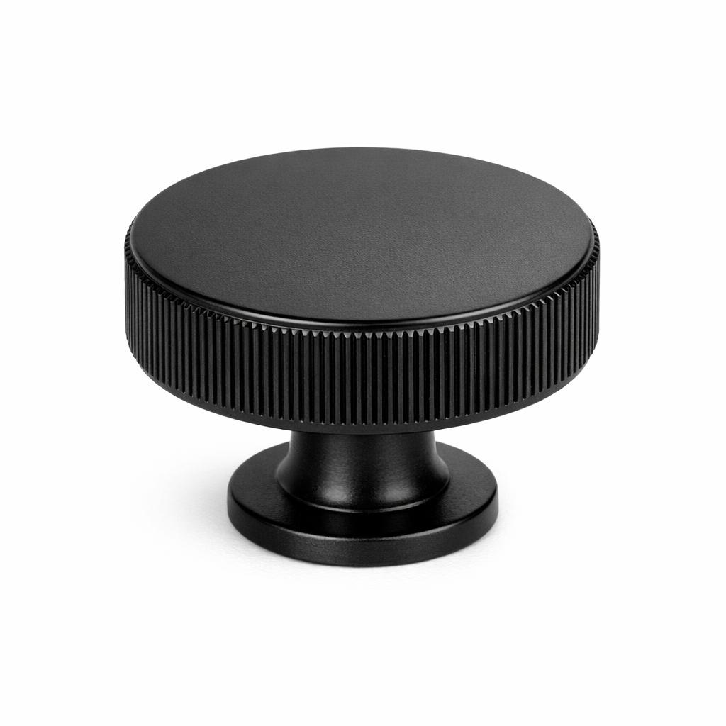 Commercial product photograph. A single residential cabinet knob. Knurled surface texture. Round Kno