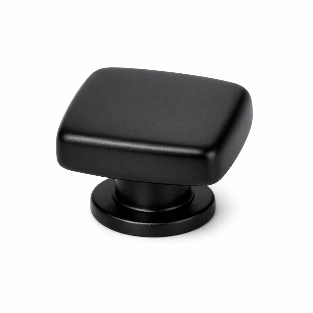 Commercial product photograph. A single residential cabinet knob. Smooth surface texture. Round Knob shape. Matte Black metal finish. Small circular base plate, single mounting post, approximately 1-1/4 inch diameter. Photographed on pure white seamless background (#FFFFFF). Studio softbox lighting, soft shadow directly underneath only. Macro lens, sharp focus throughout. Photorealistic real metal hardware. Not a 3D render. Not an illustration. Not CGI. Real cabinet hardware product photography quality. Variation 1: Providence style cabinet knob: a square knob with softly rounded edges and corners, a rounded-cube form wider and flatter than a true cube, flat top face, sitting on a small circular base. Smooth surface, no texture, no ribbing, no decorative details..