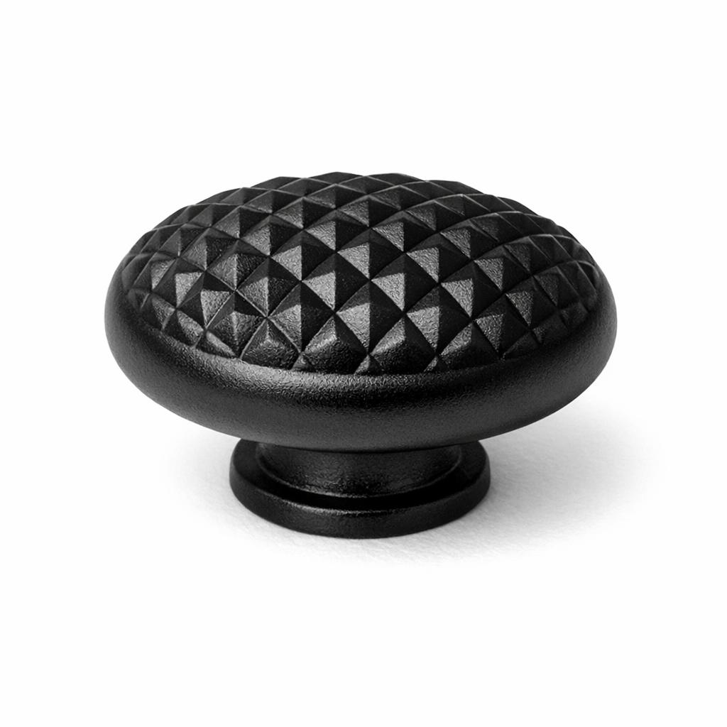 Commercial product photograph. A single residential cabinet knob. Geometric surface texture. Round K
