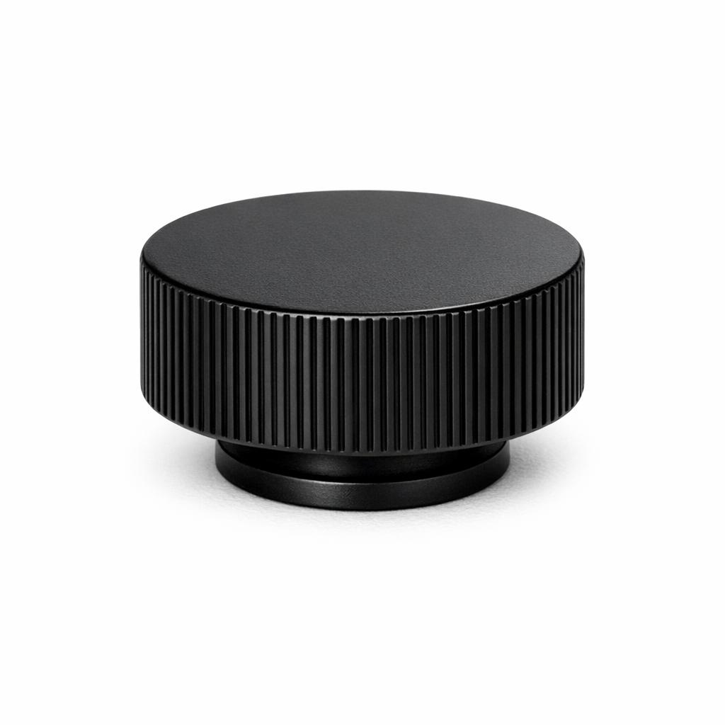 Commercial product photograph. A single residential cabinet knob. Ribbed surface texture. Round Knob shape. Matte Black 