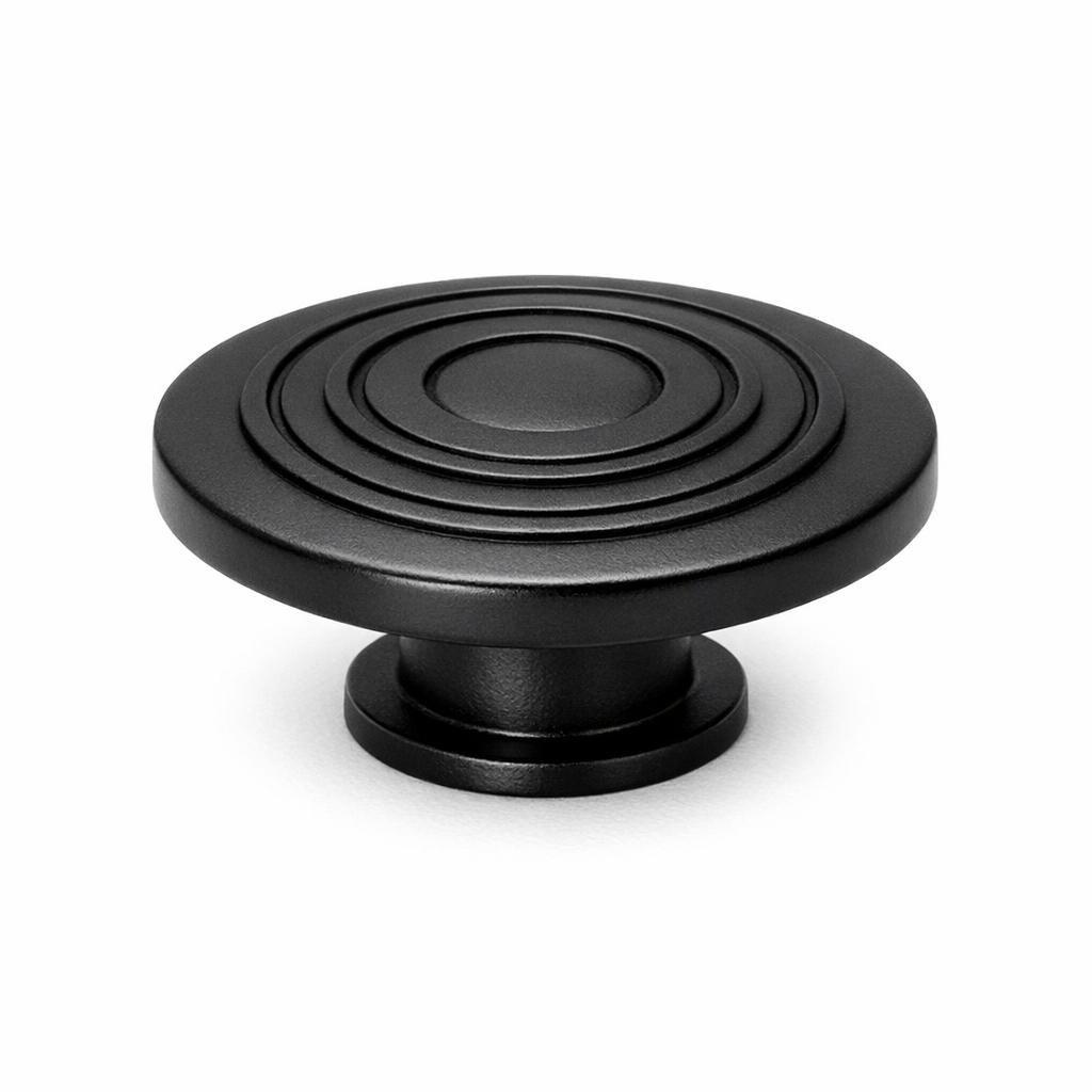Commercial product photograph. A single residential cabinet knob. Geometric surface texture. Round K