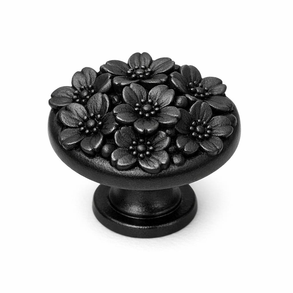 Commercial product photograph. A single residential cabinet knob. Floral surface texture. Round Knob shape. Matte Black metal finish. Small circular base plate, single mounting post, approximately 1-1/4 inch diameter. Photographed on pure white seamless background (#FFFFFF). Studio softbox lighting, soft shadow directly underneath only. Macro lens, sharp focus throughout. Photorealistic real metal hardware. Not a 3D render. Not an illustration. Not CGI. Real cabinet hardware product photography quality. Variation 3: Cabinet knob sculpted as a cherry blossom cluster, several small five-petal flowers grouped together in raised relief with fine dimensional detail, small round base. Cast metal floral hardware..