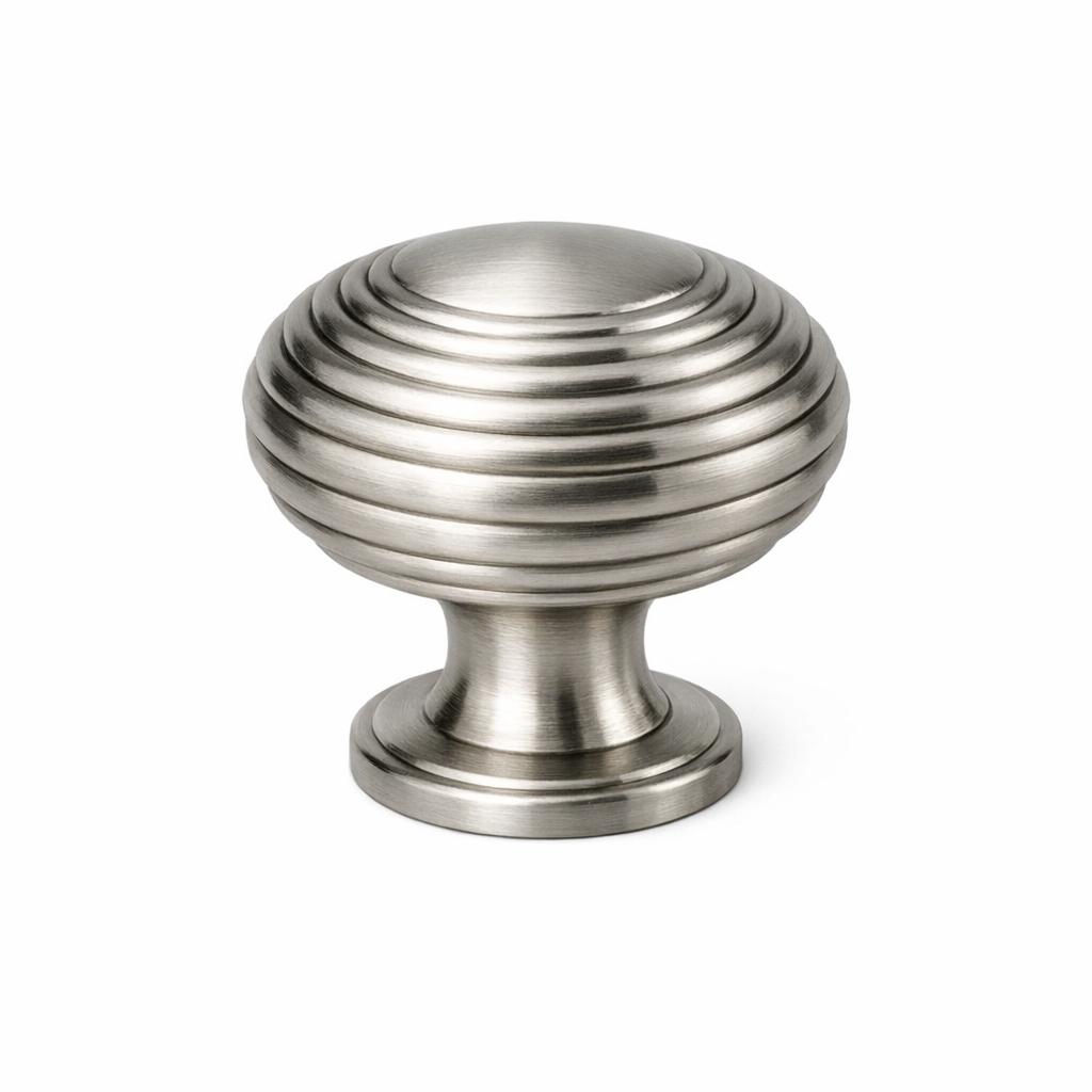 A single product photograph of a Ribbed Round Knob cabinet knob in Brushed Nickel finish. Shot straight-on ...