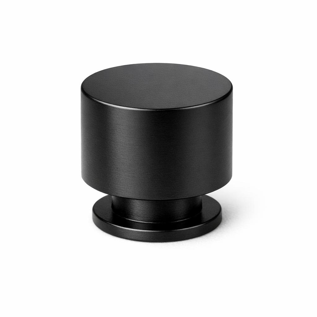 Commercial product photograph. A single residential cabinet knob. Smooth surface texture. Round Knob shape. Matte Black metal finish. Small circular base plate, single mounting post, approximately 1-1/4 inch diameter. Photographed on pure white seamless background (#FFFFFF). Studio softbox lighting, soft shadow directly underneath only. Macro lens, sharp focus throughout. Photorealistic real metal hardware. Not a 3D render. Not an illustration. Not CGI. Real cabinet hardware product photography quality. Variation 5: Cylinder knob: straight cylindrical shape, flat top, no dome, straight sides, circular base plate. Industrial modern style..
