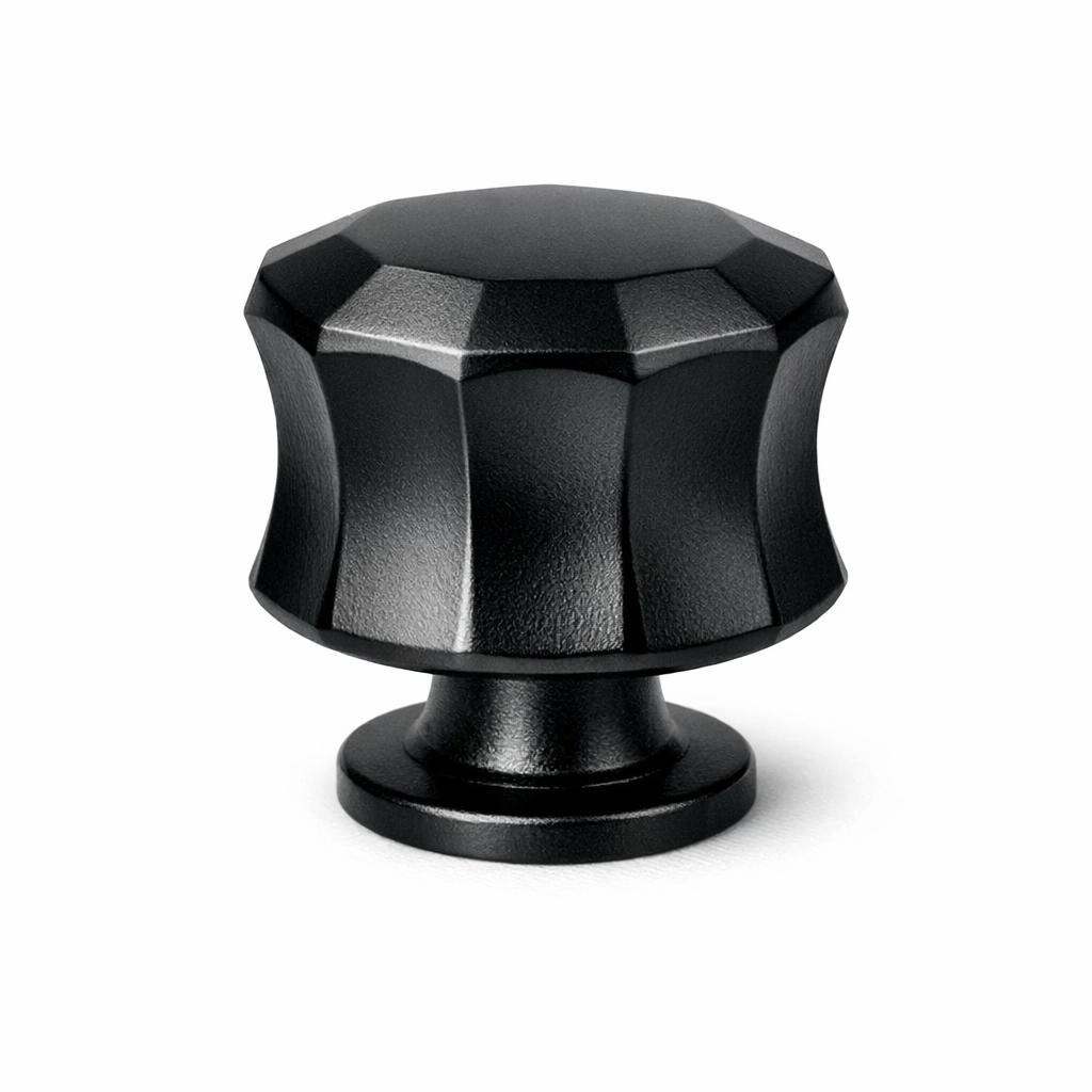 Commercial product photograph. A single residential cabinet knob. Faceted surface texture. Round Knob shape. Matte Black metal finish. Small circular base plate, single mounting post, approximately 1-1/4 inch diameter. Photographed on pure white seamless background (#FFFFFF). Studio softbox lighting, soft shadow directly underneath only. Macro lens, sharp focus throughout. Photorealistic real metal hardware. Not a 3D render. Not an illustration. Not CGI. Real cabinet hardware product photography quality. Variation 5: Overland style cabinet knob: a bell shape with concave flared sides cut into vertical faceted planes, sharp angular edges from top to base..