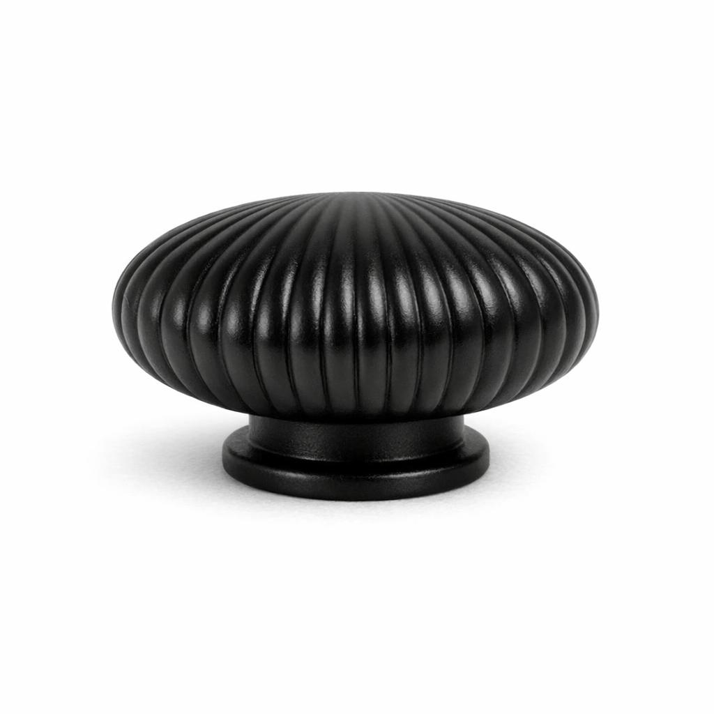 Commercial product photograph. A single residential cabinet knob. Ribbed surface texture. Round Knob shape. Matte Black 