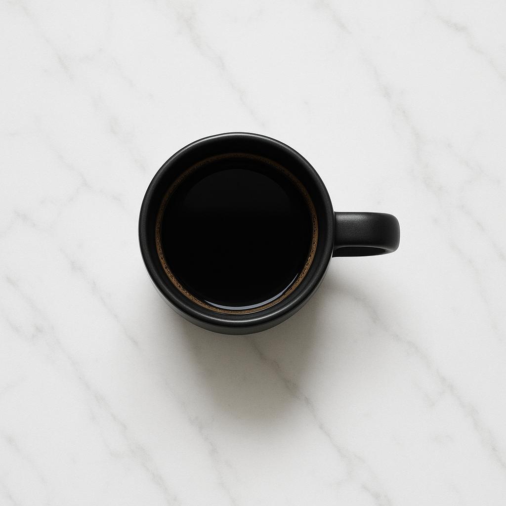 Black coffee cup on white marble surface, top-down view, minimal shadows, clean aesthetic